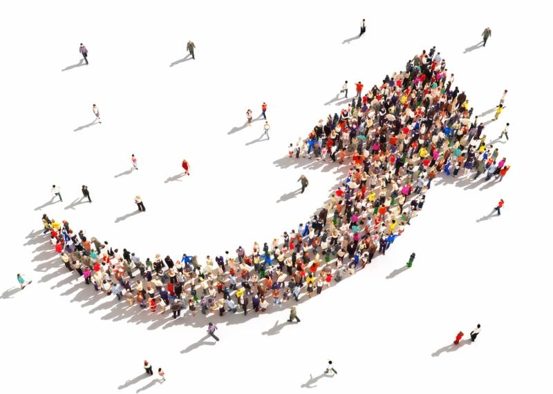Large group of people in the shape of an arrow pointing up symbolizing direction , progress or growth.