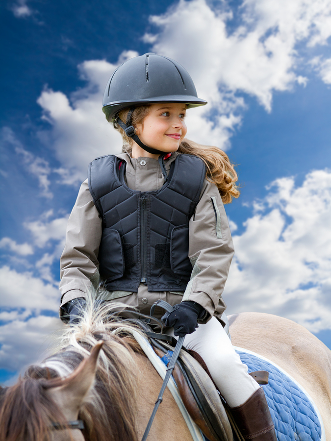 Horseback riding, lovely equestrian - little girl is riding a horse
