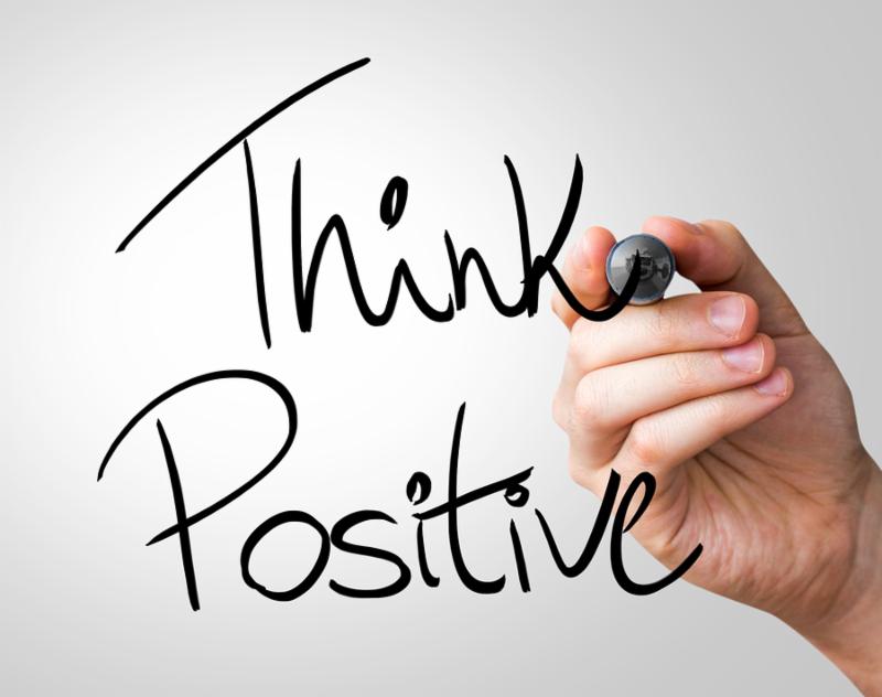 Think Positive hand writing with a black mark on a transparent board