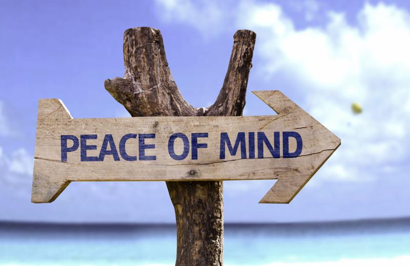 Peace of Mind wooden sign with a beach on background 