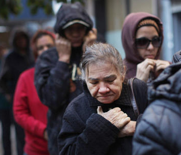older woman looking ashamed in a food pantry line